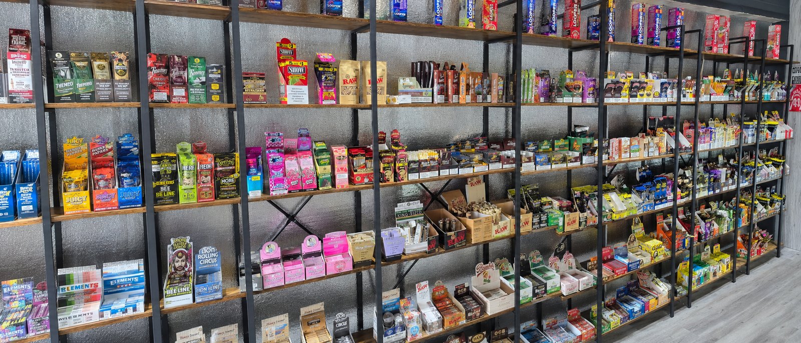 Rolling papers and wraps wall inside iSmokee Kissimmee — RAW, Elements, Juicy Jay's, Blazy Susan, OCB and Lion Rolling Circus
